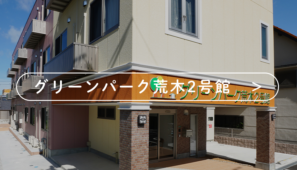 グリーンパーク斎木2号館の建物外観。看板が目立つ介護施設の入口付近。